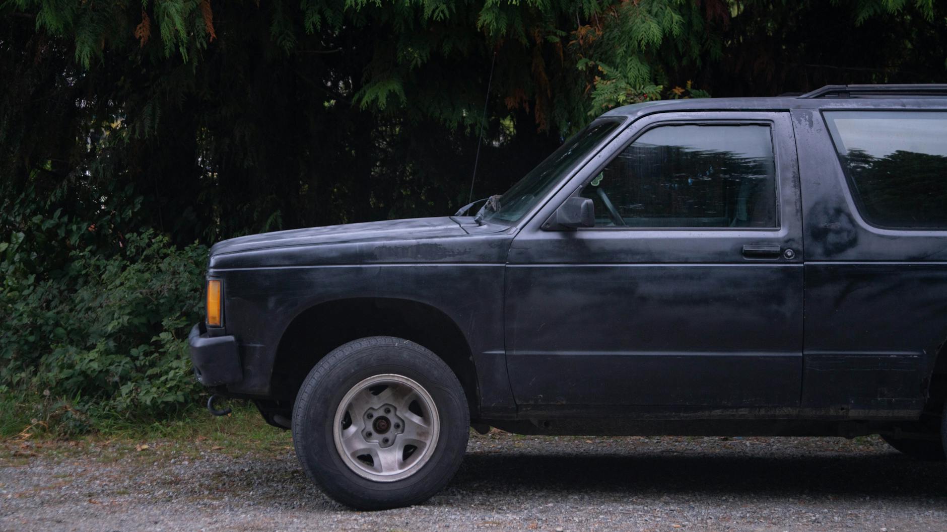 Czarny SUV na żwirowej drodze wśród zieleni w Ucluelet w Kanadzie