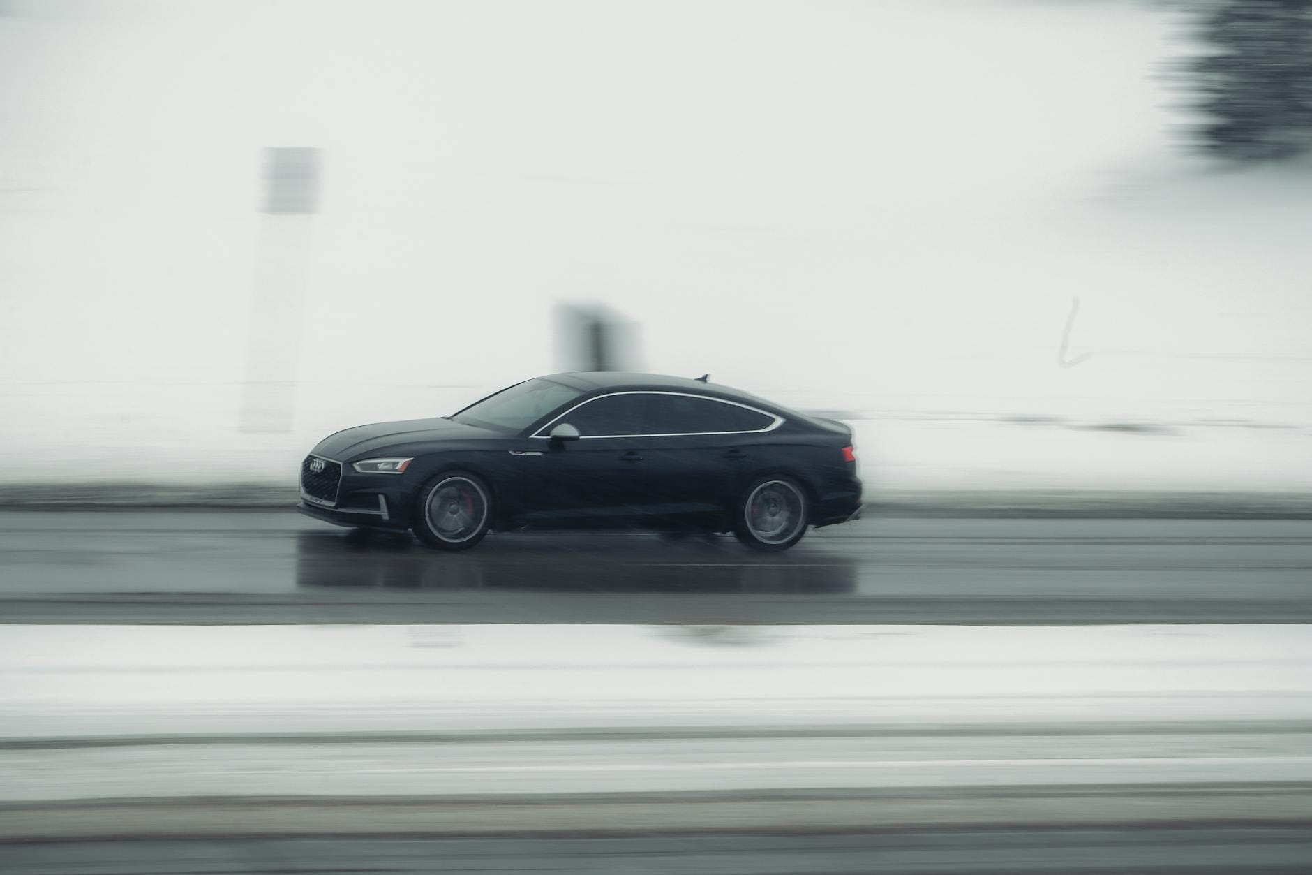 Czarny samochód jedzie zimą po ośnieżonej drodze w Calgary w Kanadzie