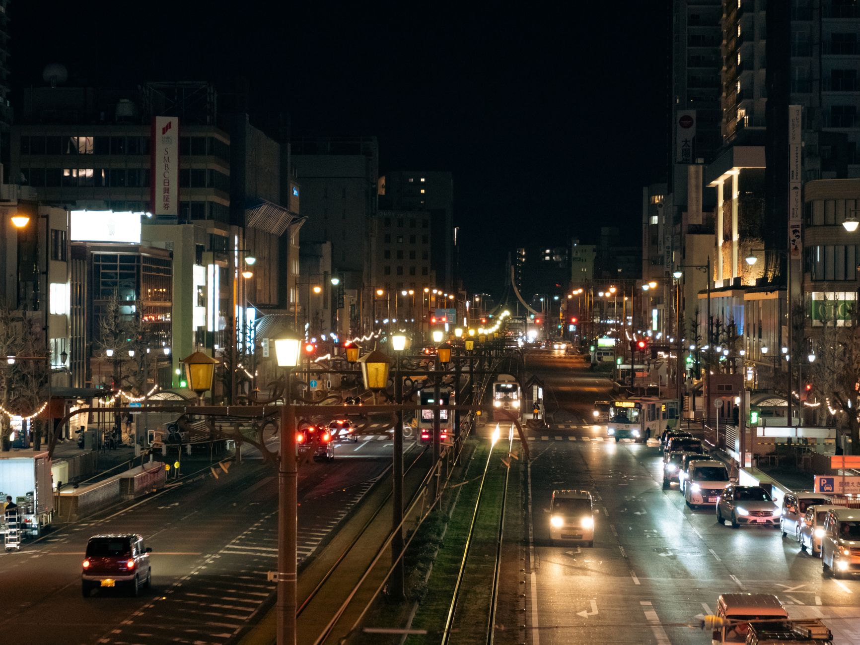 Oświetlona nocą ulica w Toyohashi z tętniącym życiem miejskim