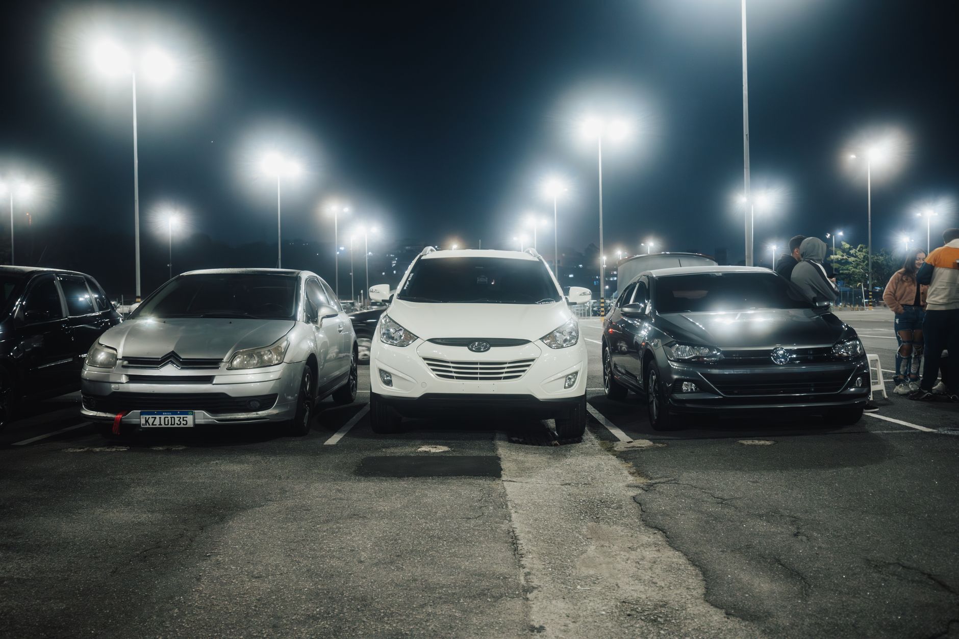 Nocny dobrze oświetlony parking z zaparkowanymi samochodami