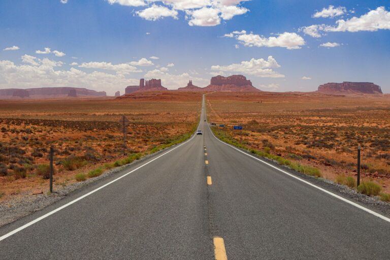Pusta autostrada przez Monument Valley pod błękitnym niebem